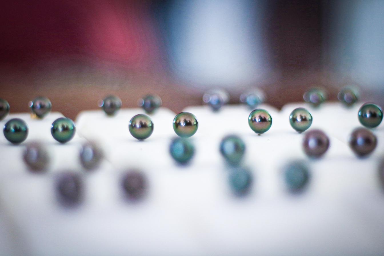 Perles noires de Tahaa photographiées en gros plan, lumière et reflets